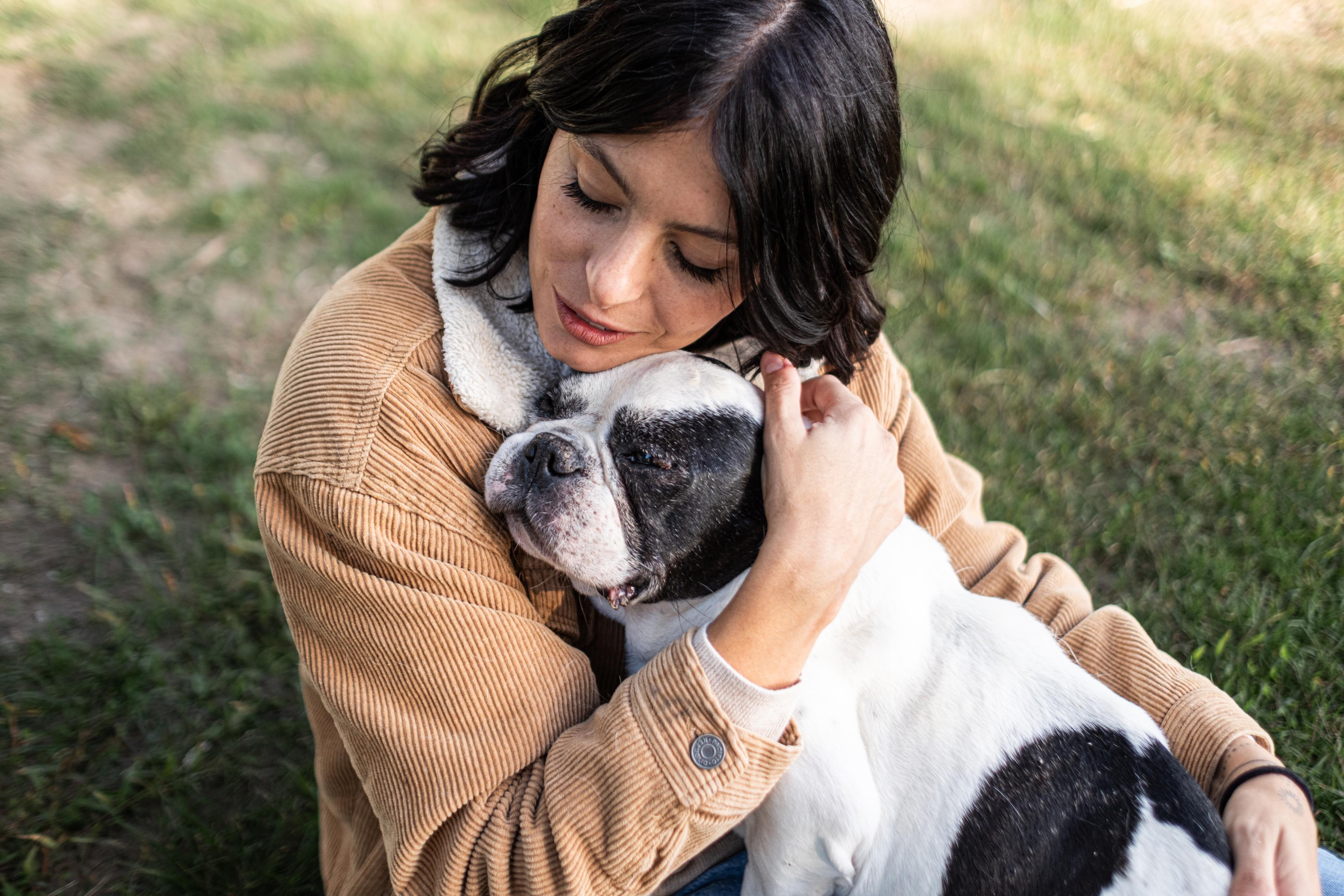 Donna mora e bouledogue francese si abbracciano sereni in primo piano